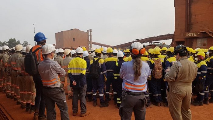 The picture shows all workers standing on the construction site for the safety Kick-off meeting in Guinea.