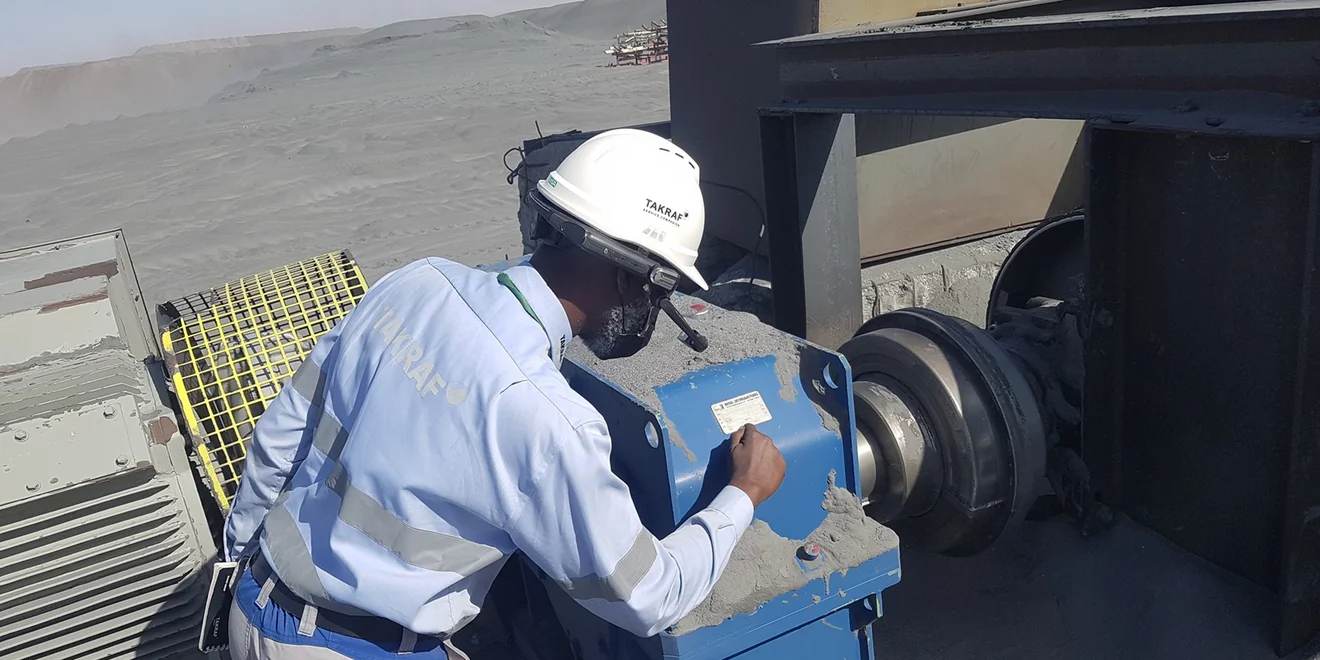 A man checking out the details on a sign at a conveyor in Mauretania.