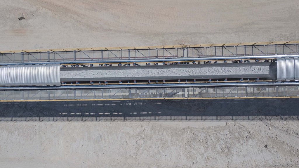 The picture shows a representative conveyor belt from Chile with copper ore being transported on an overland conveyor at another TAKRAF project. 