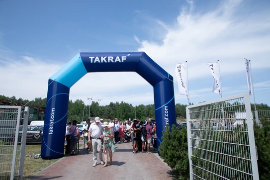 An oversized archway that serves as an entrance gate. Many people are standing in front of it, waiting to be let in.