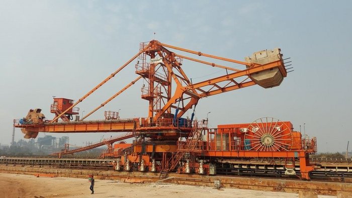 A red TAKRAF Bucket-Wheel Reclaimer stands outside.