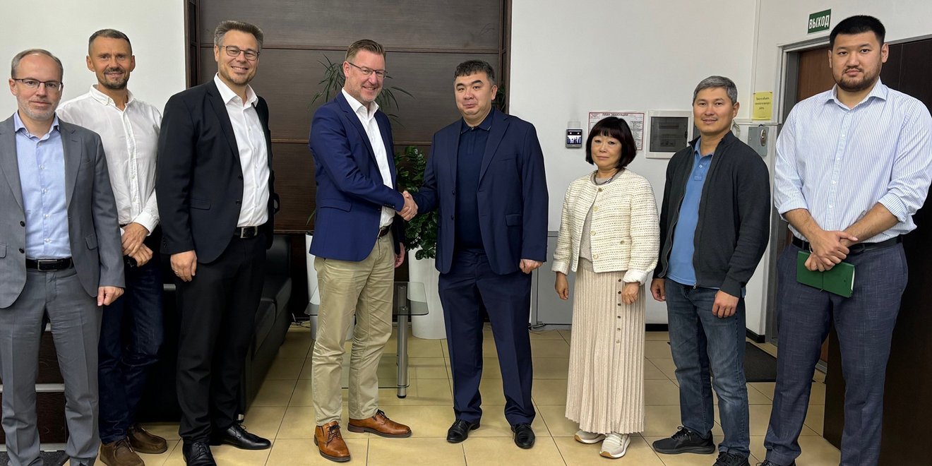 Thomas Jabs, TAKRAF Group CEO and Adil Tastanov, PSI Managing Director, shake hands together with senior colleagues from TAKRAF Group and PSI Minerals Technologies in attendance.
