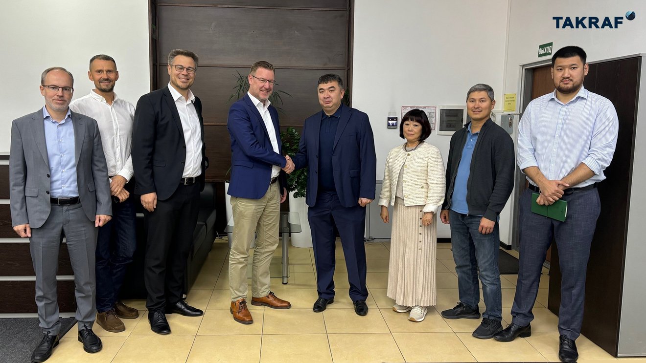 Thomas Jabs, TAKRAF Group CEO and Adil Tastanov, PSI Managing Director, shake hands together with senior colleagues from TAKRAF Group and PSI Minerals Technologies in attendance.