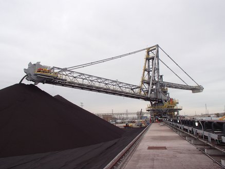 Combined bucket-wheel stacker and reclaimer for ioron ore pellets
