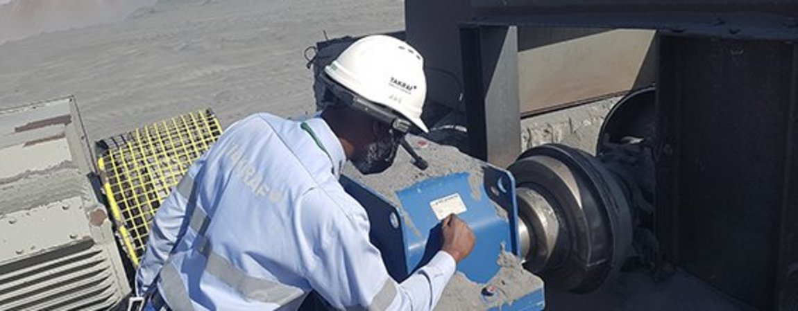 A TAKRAF employee is maintaining the equipment by means of smart glasses