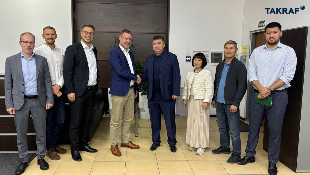 Thomas Jabs, TAKRAF Group CEO (center left) and Adil Tastanov, PSI Managing Director (center right), shake hands together with senior colleagues from TAKRAF Group and PSI Minerals Technologies in attendance.