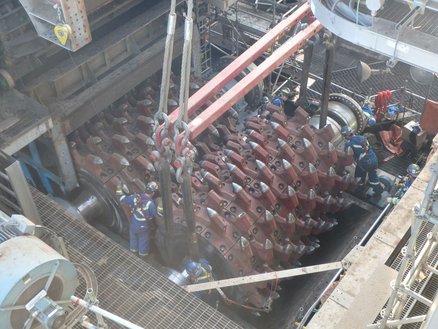 The roller of a double roll crusher is lifted out for renewal.