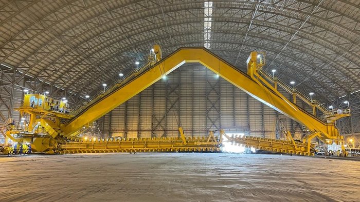 A yellow TAKRAF Portal Reclaimer stand in a hall.