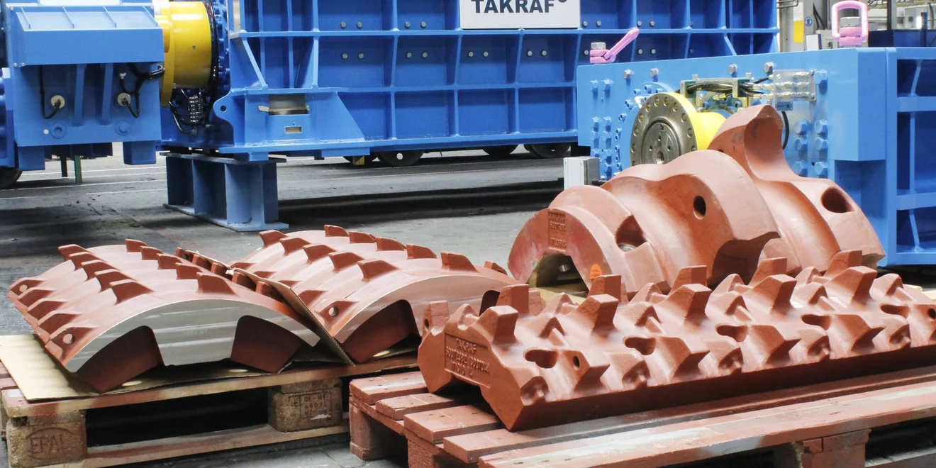 Several crushing teeth segments on pallets waiting to be transported.