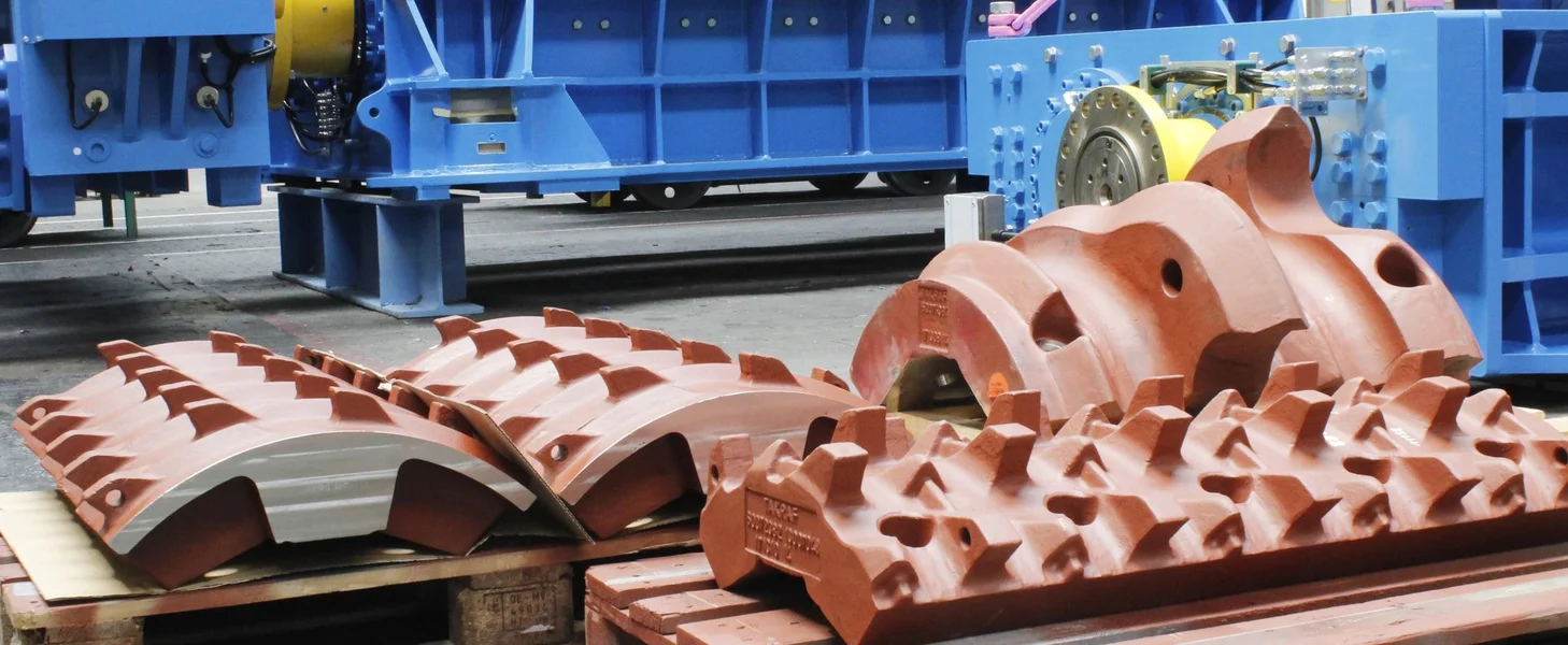 Several crushing teeth segments on pallets waiting to be transported.
